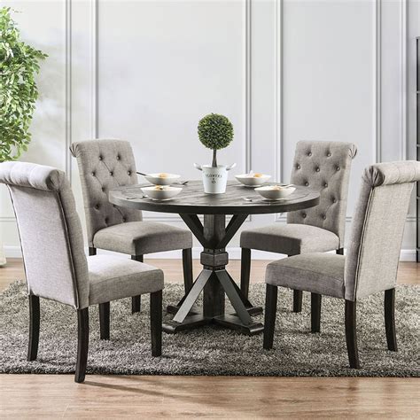 Round chandelier adorns a rectangular dining table finished with a gray wash trestle dining table on a gray greek key rug in a transitional dining room design. Dining Room Sets | Dallas Designer Furniture