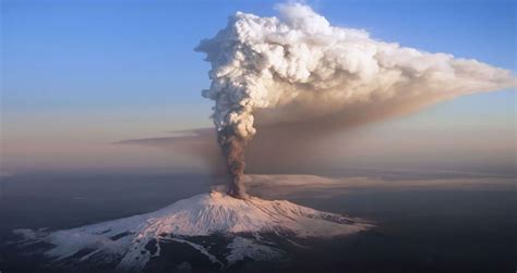 Watch the dark orange lava can be seen shooting out of the top of mount etna and dripping down its sides. Volcan etna