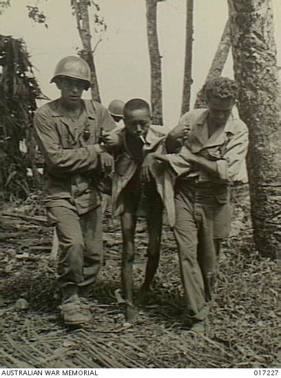 Lying on stretchers are some of the 63 emaciated american pows liberated in fuchsmuehl, germany. New Guinea. 5 June 1944. Two US soldiers assist emaciated ...