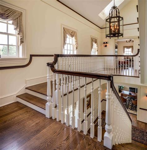 A blonde finish on the railing feels fresh against white trim, while a midcentury modern sideboard tucked below the stairs adds storage. farmhouse staircase ideas traditional with detailed architecture style fine art prints | Home ...