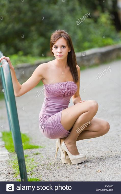 This completely natural pigtailed girlfriend. Teen girl pretty in fanciful minidress squatting in park ...