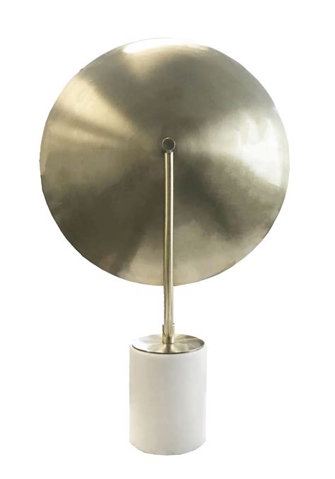 The eclipse lamp is a simple, wooden circle that hangs on a wall and fades up to a soft glow when you turn it. Eclipse Lamp Brass - Marble - MRD Home