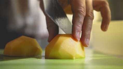 Closeup of hand with knife cutting fresh vegetable. Woman cutting ...