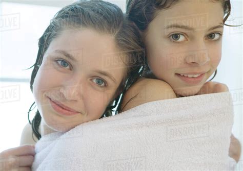 He abuses his sister like a dog in the shower. Two preteen girls sharing towel - Stock Photo - Dissolve