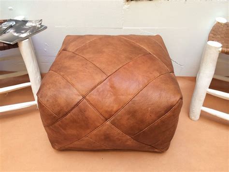 Incorporating a leather effect with a rather classical style of ottoman, this item is able to offer you some degree of comfort due to the level of padding. S l1600 | Leather pouf ottoman, Moroccan leather pouf ...