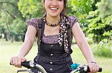 asian bicycle riding woman park stock