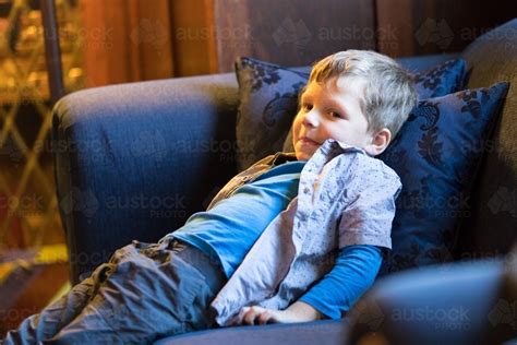 Side swept hair with side fade. Image of 4 year old boy sitting back on lounge smiling ...