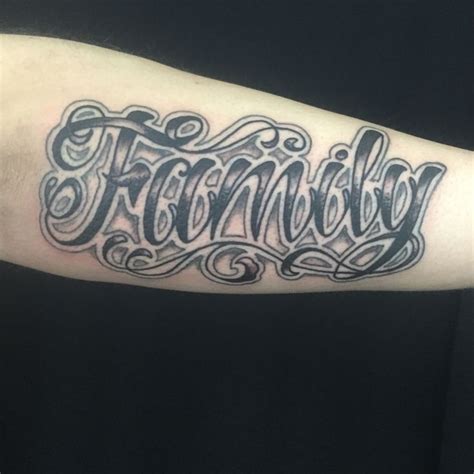 The tattoo is wide, and takes up a significant portion of the arm. family | Old school tattoo designs, Tattoo script