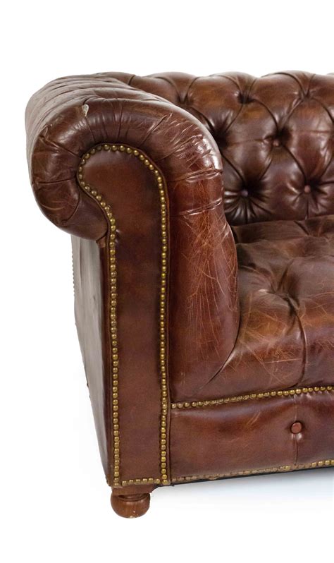 The chesterfield leather sofa with it's unique low back style, deep buttoned arms and back complemented with a buttoned front border. Chocolate brown leather chesterfield sofa