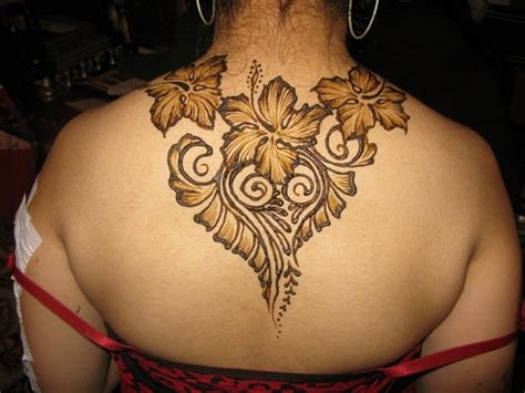 A sparkly black, gold, and green design featuring floral images is rendered across the wearer's back in this henna tattoo. Best Henna Tattoos for Back: Bold and Beautiful Designs ...