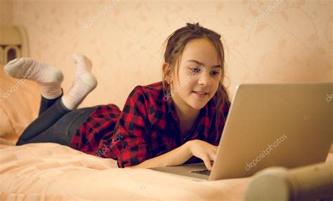 2 teen girls, injured by train,. Portrait of teenage girl lying on bed and using laptop — Stock Photo © Kryzhov #105614812