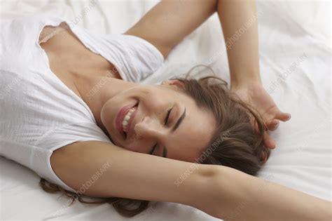 Wait 7 days after painting before use, do not apply strips to paper or soft surfaces on frame, remove hanging hardware from back of frame, failure to follow instructions carefully may cause damage. Smiling woman stretching in bed - Stock Image - F006/4212 ...