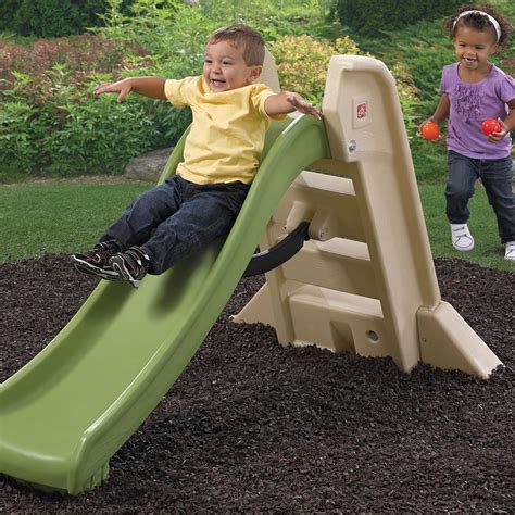 Child sliding down a slide. Naturally Playful Big Folding Slide | Kids Slide | Step2