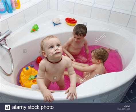 Baby steckt in abflusssieb von badewanne: Kinder spielen in der Badewanne mit rosa Wasser ...