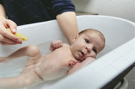 Bath time is often a joyous experience for parents. Newborn in the bathtub | High-Quality People Images ...