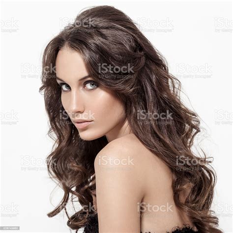 Headshot of beautiful caucasian brunette posing in front of grey background. Beautiful Brunette Woman Curly Long Hair Stock Photo ...