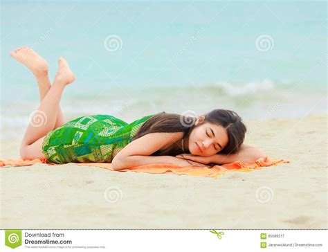 The shot is taken from above looking down on her from the thighs to her head. Teen Girl Lying Down On Hawaiian Beach, Resting By Ocean ...