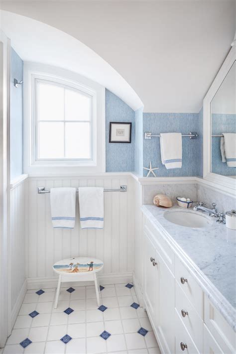 It has a yellow freestanding tub illuminated by a glass chandelier and sconce. 14 Beautiful Beach Cottage Bathroom Designs