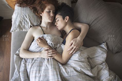 Beautiful brunettes play with each other in bed before work. Overhead view of lesbians sleeping on bed at home stock ...