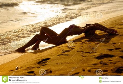 Find images of beach body. Beautiful Woman Lays On Sand Of Beach In Sunset Stock Photo - Image: 59776402