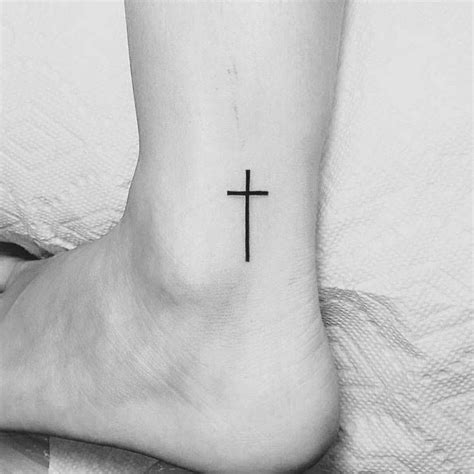 Cross arrow tattoo on side wrist. Christian cross tattoo on the ankle.