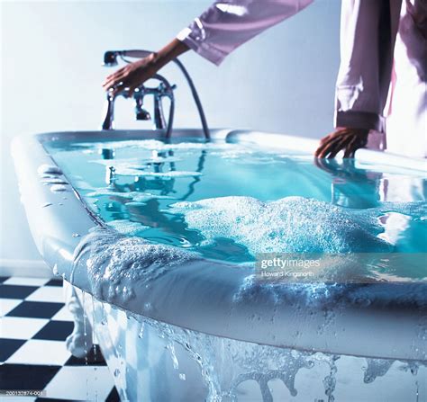 The overflow tube is a safety feature that channels water that has overfilled the tub back down into the drain pipes before it can spill over the edge of the tub. Woman Turning Bath Tap Water Overflowing Stock Photo ...