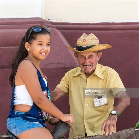 Men's jacket & coat promotion. Old man renting out donkey rides to a little girl in the ...