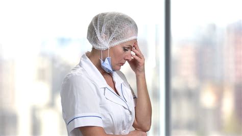 Worried and tired female doctor. Upset mature female doctor holding ...