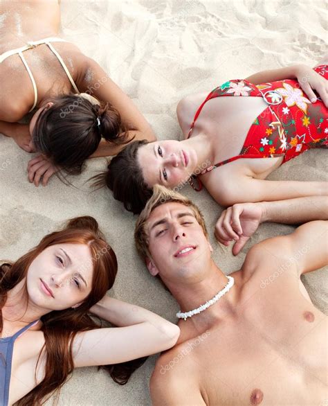 4 teen girls lying down, arm in arm, holding hands, chatting. Girls laying down together on a sand beach — Stock Photo ...