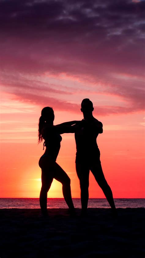 Si bailas con tu corazón, el cuerpo le seguirá. Pareja bailando en la playa al atardecer silueta sombra ...
