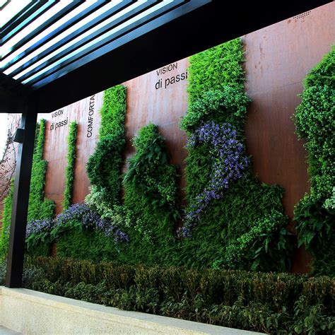 The faux privacy hedge is made of polyester fabric to withstand weather conditions and resist fading. Inspirational green wall from our client! #buyer'sshow | Artificial hedges, Green wall, Hedges