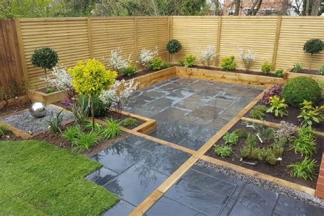 A formal outdoor space with a gravel and long paving stones plus a wooden deck and trees lining the path. Gardoo Sleepers | Gardoo