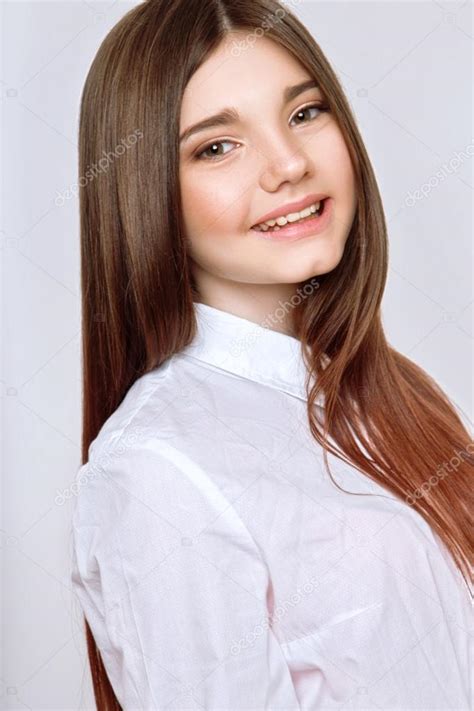 With the fashion world trends changing every other season. A beautiful 13-years old girl smiled and dressed in a white blouse in studio on white background ...