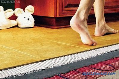 Wärmewiderstand der bodenkonstruktion oberhalb heizmatte sollte so gering wie möglich sein. Elektrische Fußbodenheizung mit den Händen unter der ...