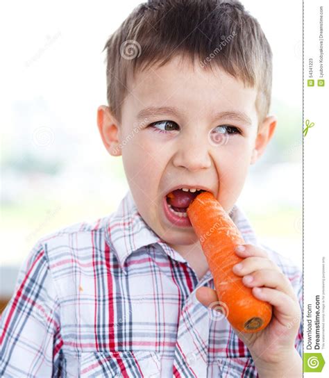 Boy is eating carrot stock image. Image of cute, brunette - 54341223