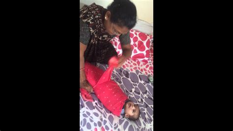 The baby is kept on the legs with its face towards the ground so that the face and tummy of the baby are touching the mother's legs and the nose. Indian baby massage and after bath wrapping baby in cotton ...