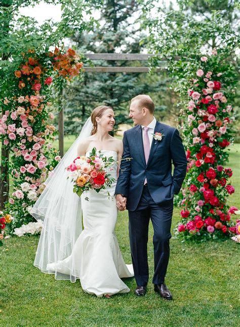 Romantic Couple with Colorful Flower-Covered Wedding Arch