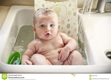 Some baby bathtubs can be placed in the kitchen sink. Baby bath sink stock image. Image of nude, kitchen, chubby ...