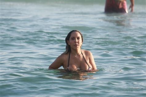 O mar com tons de azul esverdeado é calmo e forma várias piscinas naturais. Mulher Melão mergulha e mostra demais em praia do Rio de ...