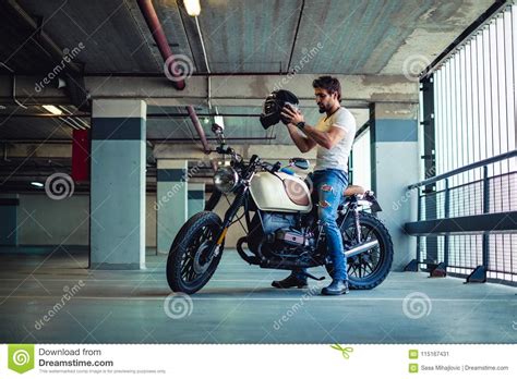 Visit our website to order today Man Putting On Motorcycle Helmet In A Garage Stock Image ...