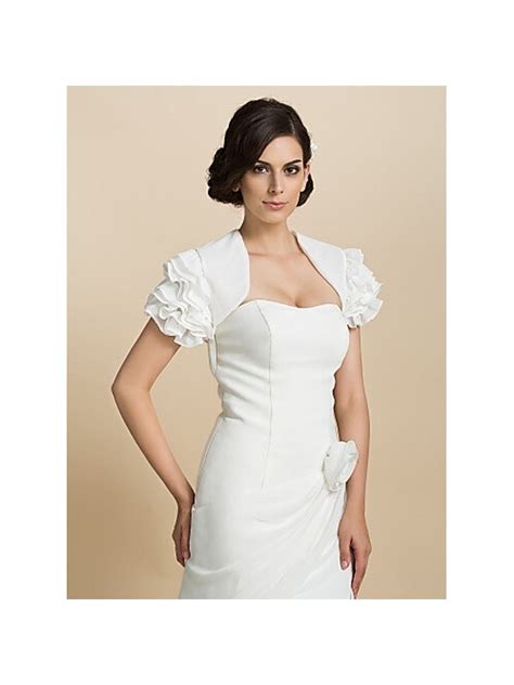 Il corpetto è caratterizzato da la fodera in raso colore champagne coperta da un leggero pizzo bianco che compongono le maniche corte. Coprispalle da Sposa in chiffon con maniche corte