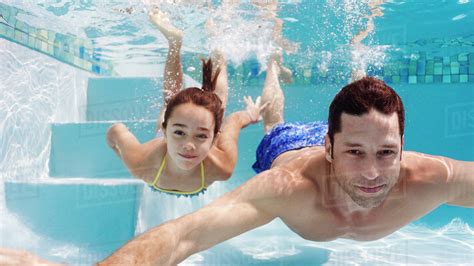 Anthea fraser, margaret tyzack, audible studios: Father and daughter swimming in pool - Stock Photo - Dissolve