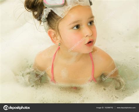 Tipps für die wahl der richtigen badewanne fürs kleine bad. Kleines schönes Mädchen spielt mit Wasser und Schaum in ...