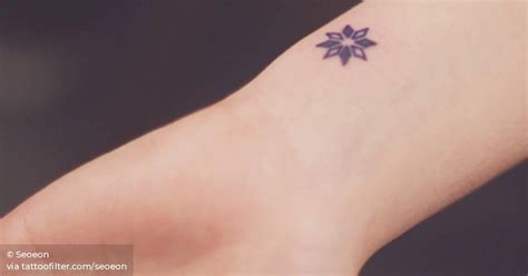 Red nautical star tattoo on left wrist. Small star tattoo on the left wrist.