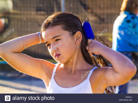 All models were 18 years of age or older at the time of depiction. Young girl at the beach brushing her wet hair after ...
